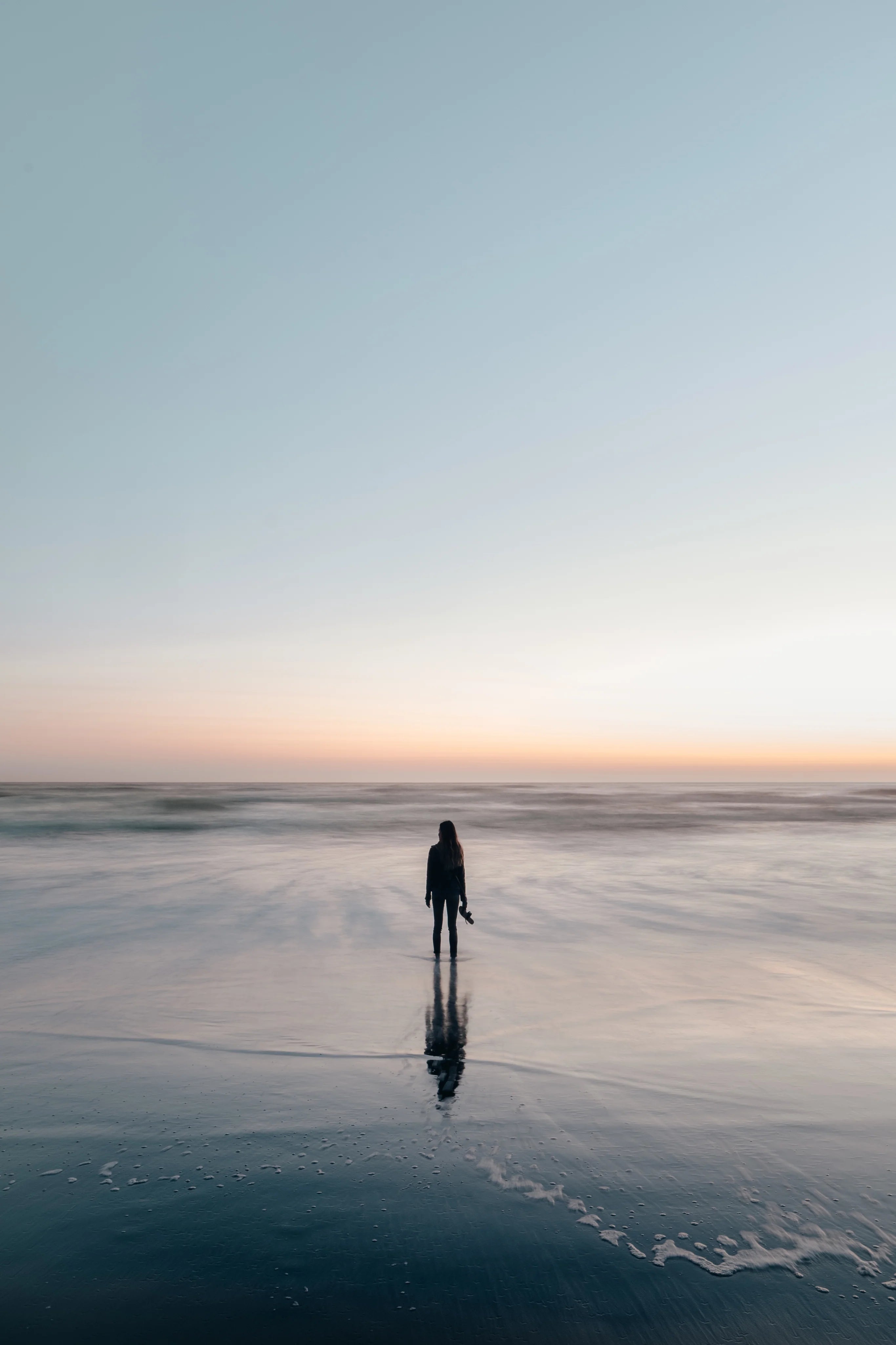 files/woman-wades-in-ocean-at-sunset.webp